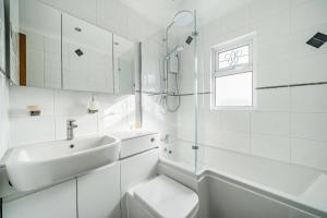 ein weißes Badezimmer mit Waschbecken und Toilette in der Unterkunft Spacious Berkshire home - Perfect for groups and contractors in Canvey