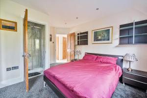 ein Schlafzimmer mit einem großen rosa Bett und einem Fenster in der Unterkunft Spacious Berkshire home - Perfect for groups and contractors in Canvey