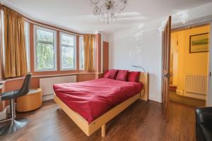 ein Schlafzimmer mit einem Bett mit einer roten Decke in der Unterkunft Spacious Berkshire home - Perfect for groups and contractors in Canvey