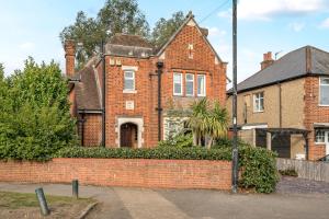 ein Backsteinhaus mit einer Backsteinmauer davor in der Unterkunft Spacious Berkshire home - Perfect for groups and contractors in Canvey + 14 Fotos