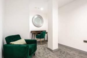 ハルにあるModern 2BR Haven in Hull City Centerのリビングルーム(緑の椅子、鏡付)