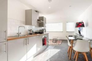 ハルにあるModern 2BR Haven in Hull City Centerの白いキャビネットとテーブルと椅子のあるキッチン +5枚の写真