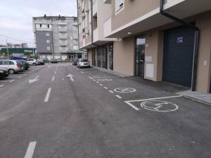 an empty parking lot with cars parked next to a building at Lux Iva apartman in Doboj