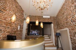 a lobby with a brick wall and a chandelier at Sardinia Otel in Amasra