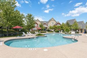 a large swimming pool with chairs and umbrellas at Alpine Breeze Getaway at Blue in Blue Mountains