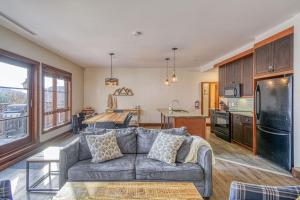 un salon avec un canapé et une cuisine dans l'établissement Versant Soleil Family Condo at Versant Nord, à Mont-Tremblant
