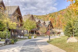 une maison avec une route en face d'une montagne dans l'établissement Versant Soleil Family Condo at Versant Nord, à Mont-Tremblant