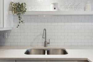 eine Edelstahlspüle in einer Küche mit weißen Fliesen in der Unterkunft Slopeside Ski In Ski Out Second Floor Condo in Blue Mountains + 32 Fotos