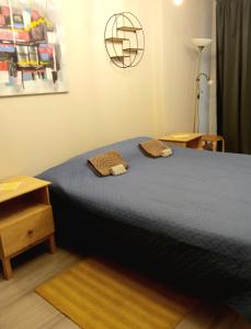 a bedroom with a blue bed with two towels on it at Cozy 2-Bedroom flat with Terrace & Parking by Alfa in Rīga