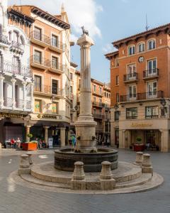 a fountain in the middle of a street with buildings at Hostal Casa Amalia in Teruel