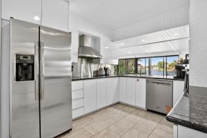 a kitchen with white cabinets and a stainless steel refrigerator at Siena Villas in Pompano Beach