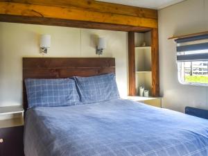 a bedroom with a blue bed with a wooden headboard at Croft - Uk50042 in Clitheroe +15 photos