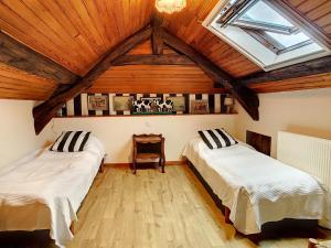 Dos camas en una habitación con techos de madera. en Restored Farmhouse for10 persons with Pool & Airco, en Doissat 35 fotos más