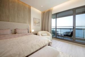 a bedroom with a bed and a view of the ocean at Silk Valley - 3B Beachfront | Private Beach Access in Al Khān +8 photos