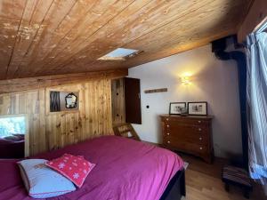 a bedroom with a purple bed and a wooden ceiling at Les Pounchus D N02 - 3P8 in La Foux d'Allos