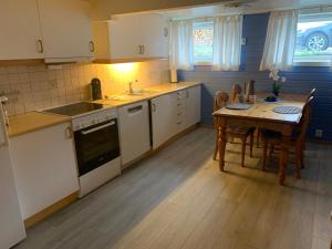 a kitchen with a table and a dining room at Northen light stay- great bus links & free parking in Tromsø