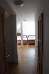 an empty room with two beds and an open door at Horská chata Hubertus in Albrechtice v Jizerských horách