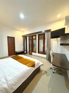Un dormitorio con una cama, un escritorio y una silla. en Livana Villa 02, en Kerobokan