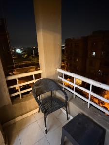 einen Stuhl, der nachts auf einem Balkon sitzt in der Unterkunft Madinaty in Madinaty