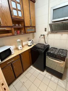 eine kleine Küche mit Herd und Mikrowelle in der Unterkunft Madinaty in Madinaty + 1 Foto