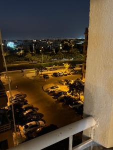 eine Aussicht von einem Balkon auf einen Parkplatz in der Nacht in der Unterkunft Madinaty in Madinaty