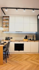 a kitchen with white cabinets and a wooden floor at EASY RENT- Szeligowskiego 15 Chodźki Residence, Free Parking, 24h Check-in in Lublin