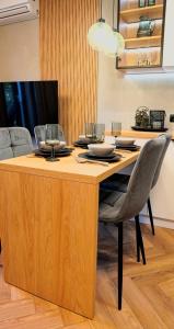 a wooden table with plates and glasses on top of it at EASY RENT- Szeligowskiego 15 Chodźki Residence, Free Parking, 24h Check-in in Lublin