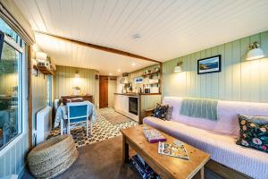a living room with a couch and a table at The Hide - Cosy Cabin with hot tub in Newton