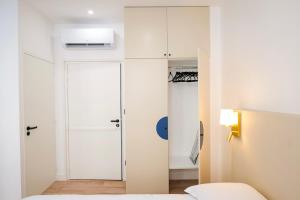 a bedroom with a bed and a closet and a door at Le Chenavard II-Coeur Lyon-Central Air Conditioning in La Celle-sous-Gouzon