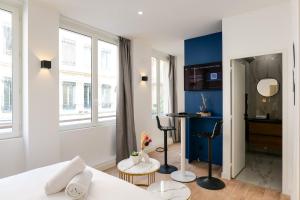 a bedroom with a white bed and a blue wall at Le Chenavard II-Coeur Lyon-Central Air Conditioning in La Celle-sous-Gouzon