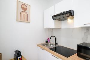 a kitchen with a sink and a microwave at Le Chenavard II-Coeur Lyon-Central Air Conditioning in La Celle-sous-Gouzon