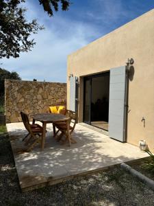 un patio avec une table et des chaises à côté d'un bâtiment dans l'établissement Villa à 900 m de la plage de Lozari, à Belgodère