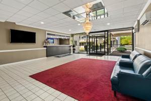 a lobby with a couch and a red rug at Americas Best Value Inn - Wilson in Wilson