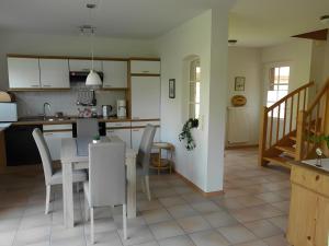 Una cocina y un comedor con mesa y sillas. en Ferienhaus Poth, en Bübbens