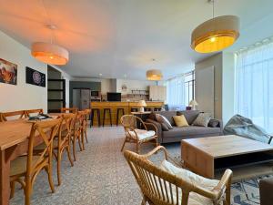 a living room with a couch and a table and chairs at l'Ancien Bistrot in Saint-Martin-de-Bréthencourt