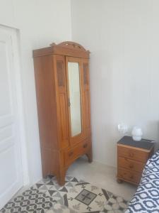 a bedroom with a wooden cabinet and a dresser at Cozy Apartment in Fougerolles du Plessis in Fougerolles-du-Plessis +4 photos