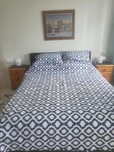 a bed with a blue and white comforter in a bedroom at Cozy Apartment in Fougerolles du Plessis in Fougerolles-du-Plessis