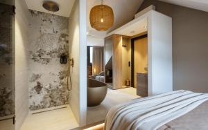 a bedroom with a bathroom with a bath tub and a bed at Myko Boutique BenB in Zwolle
