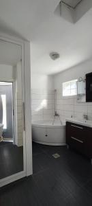 a white bathroom with a tub and a sink at Apartmany Tisno Perica in Tisno
