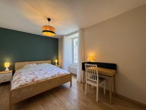 a bedroom with a bed and a desk and a window at l'Ancien Bistrot in Saint-Martin-de-Bréthencourt
