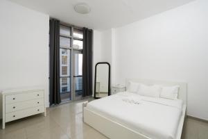 a white bedroom with a large white bed and a mirror at Superb Family Friendly Beach-Front Whole Flat, Great Views in Dubai