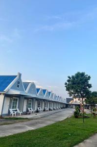 a row of houses with blue roofs on a street at Preme village in Ubon Ratchathani +24 photos