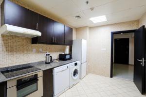 a kitchen with a refrigerator and a washer and dryer at Superb Family Friendly Beach-Front Whole Flat, Great Views in Dubai