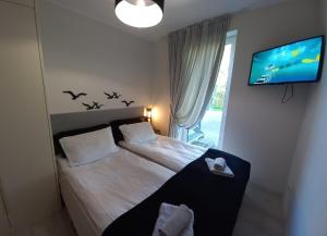 ein Schlafzimmer mit einem Bett mit Vögeln an der Wand in der Unterkunft Apartament Koszałka in Łeba