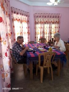 2 personnes assises à une table dans une pièce dans l'établissement Nature's peak Udawalawa, à Uda Walawe