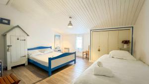 a bedroom with two beds and a blue and white bed at Charmante location au pied des dunes in Sainte-Marie-de-Ré