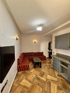 a living room with a couch and a flat screen tv at Auberge guest house1 in Imsouane