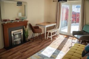 a living room with a fireplace and a table at Family-Friendly 4-Bed Swansea Stay with Parking in Landore +30 photos