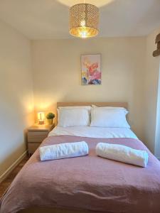 a bedroom with a large bed with two pillows on it at Family-Friendly 4-Bed Swansea Stay with Parking in Landore