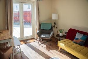 a living room with a couch and a chair and a window at Family-Friendly 4-Bed Swansea Stay with Parking in Landore